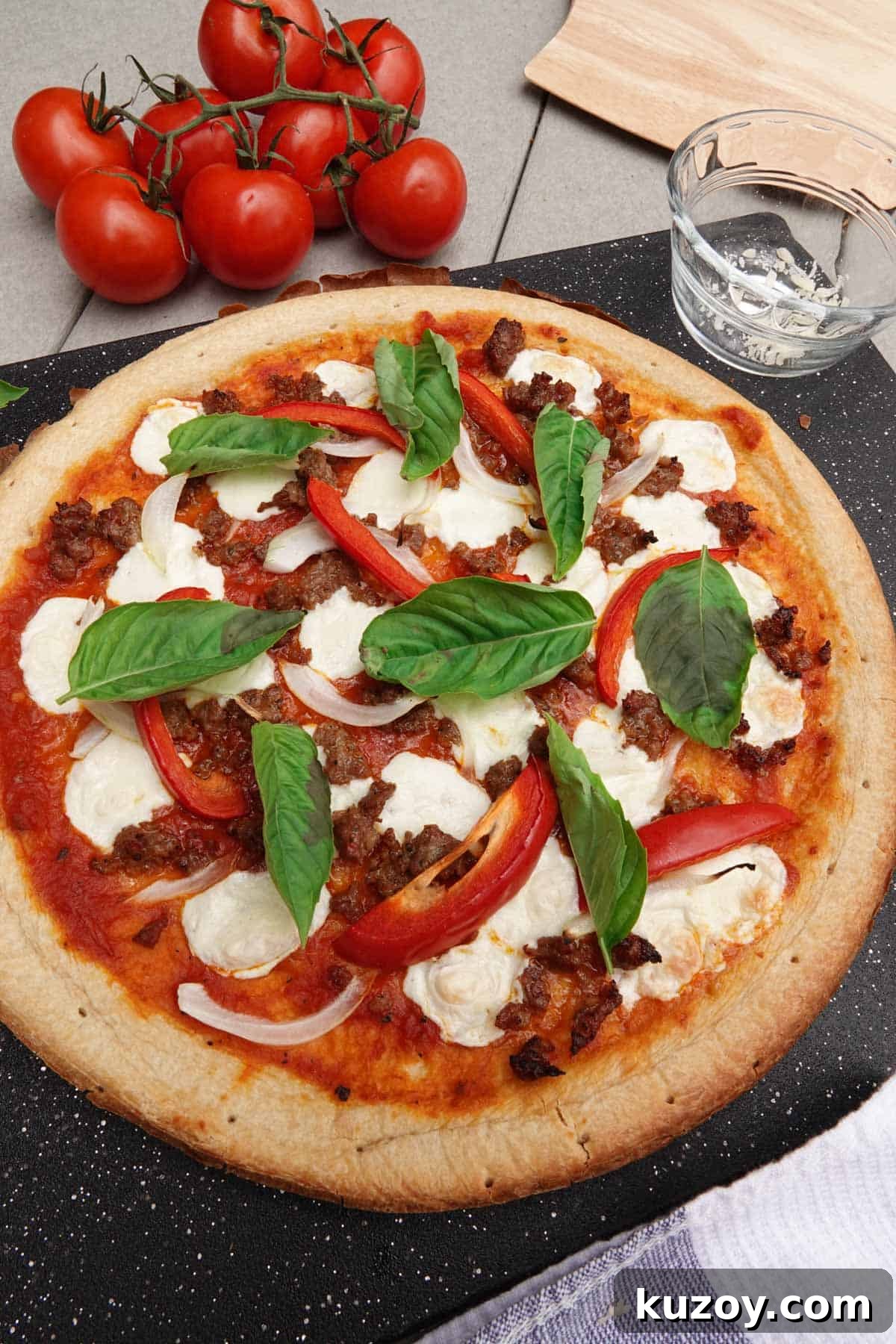 Pizza on cutting board with tomatoes on vine