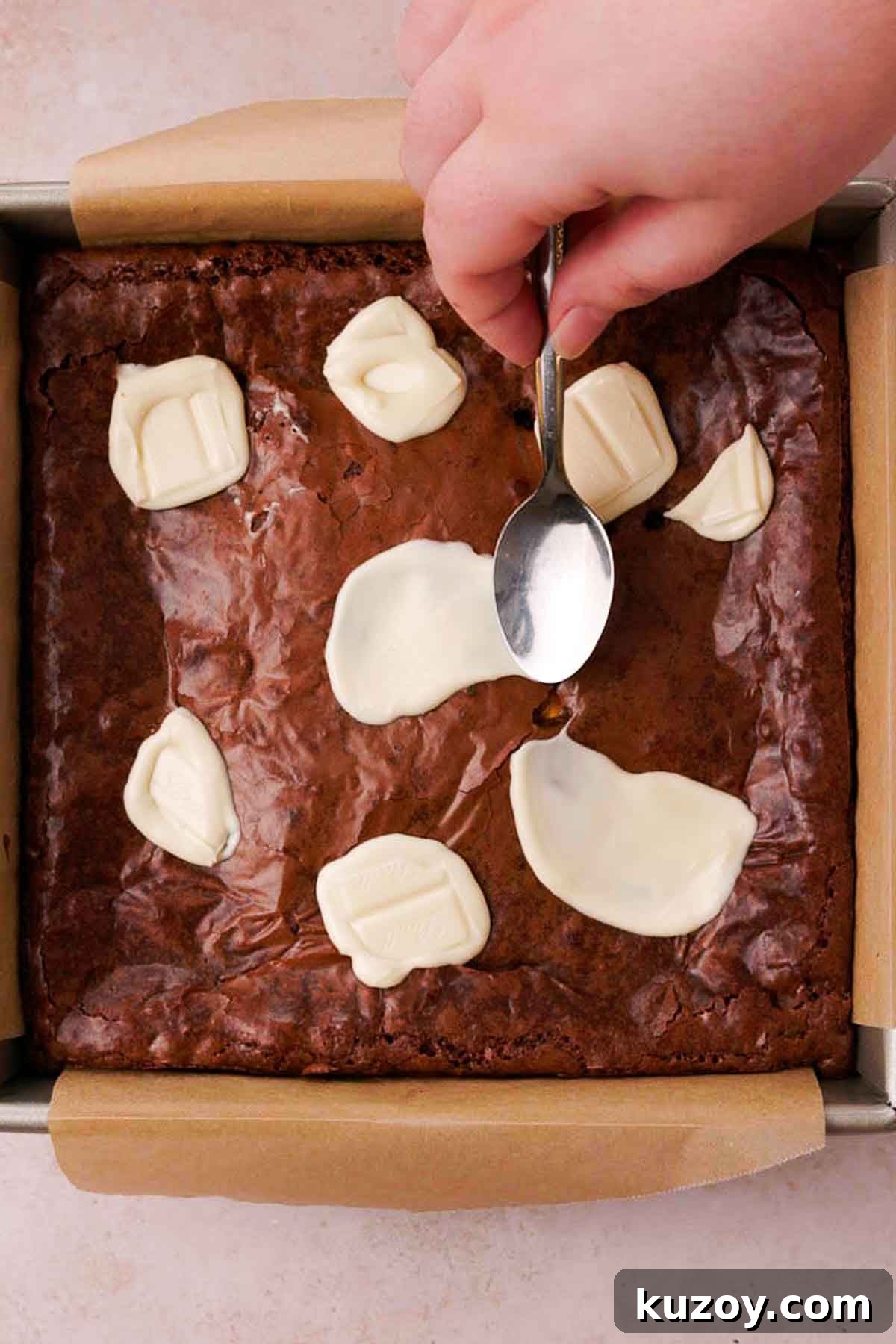 Mini Egg Brownies Recipe for Rich, Fudgy Easter Treats 11 smearing melted white chocolate with the back of a spoon onto baked brownie top