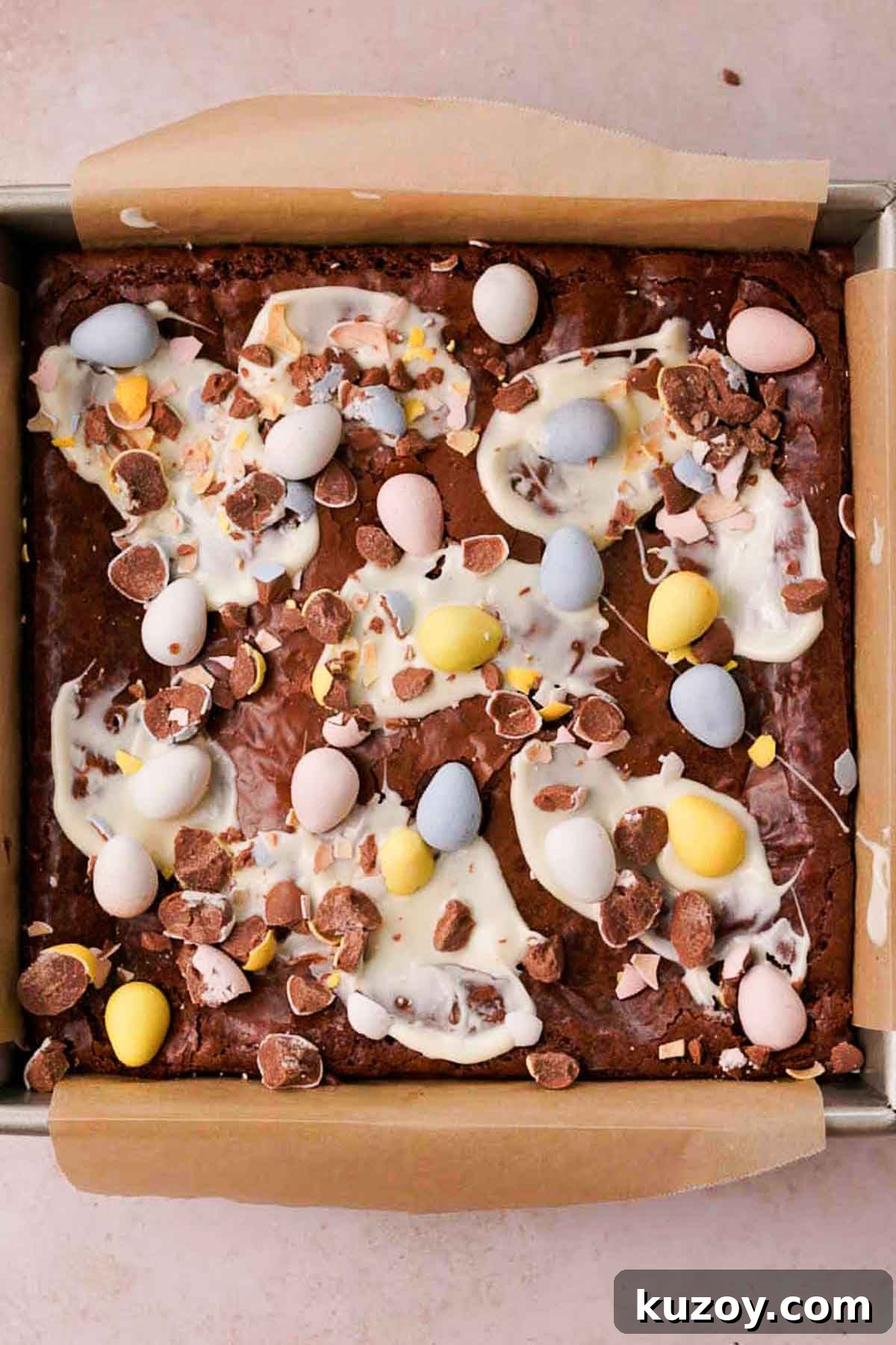 Mini Egg Brownies Recipe for Rich, Fudgy Easter Treats 12 mini egg brownies in square pan with smears of white chocolate and crushed mini eggs