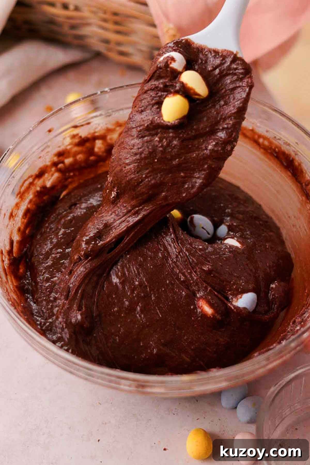 Mini Egg Brownies Recipe for Rich, Fudgy Easter Treats 9 folding chocolate mini eggs into brownie batter with a silicone spatula