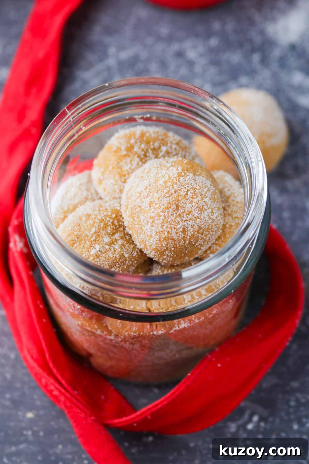 dulce de leche pastillas in a mason jar with red ribbon in the background.