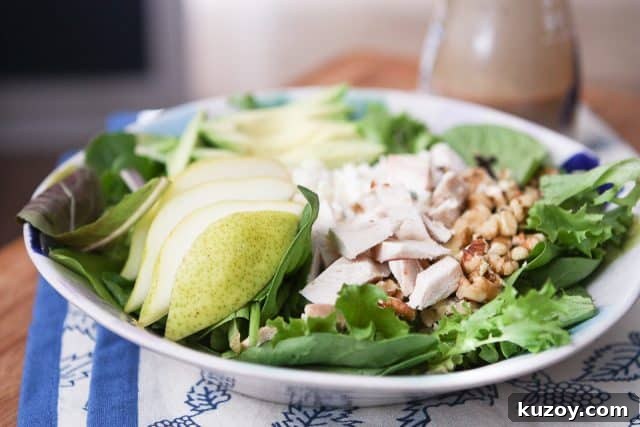 Chicken, Pear & Avocado Salad with Honey-Lime Dressing 2 salad plate with salad greens, sliced pears, chopped rotisserie chicken and walnuts