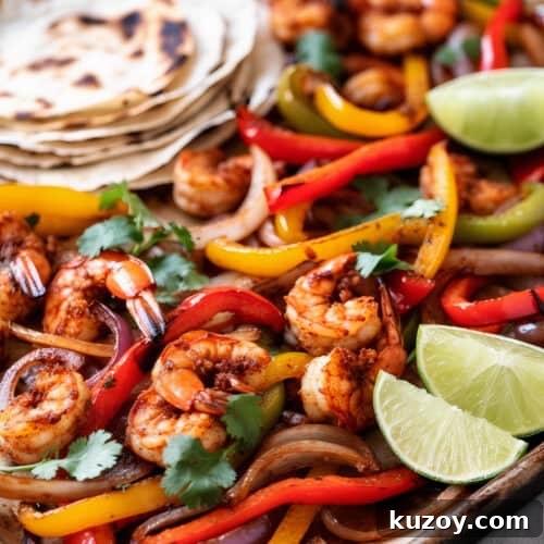 a pan of zesty shrimp sheet pan fajitas with grilled bell peppers and onions