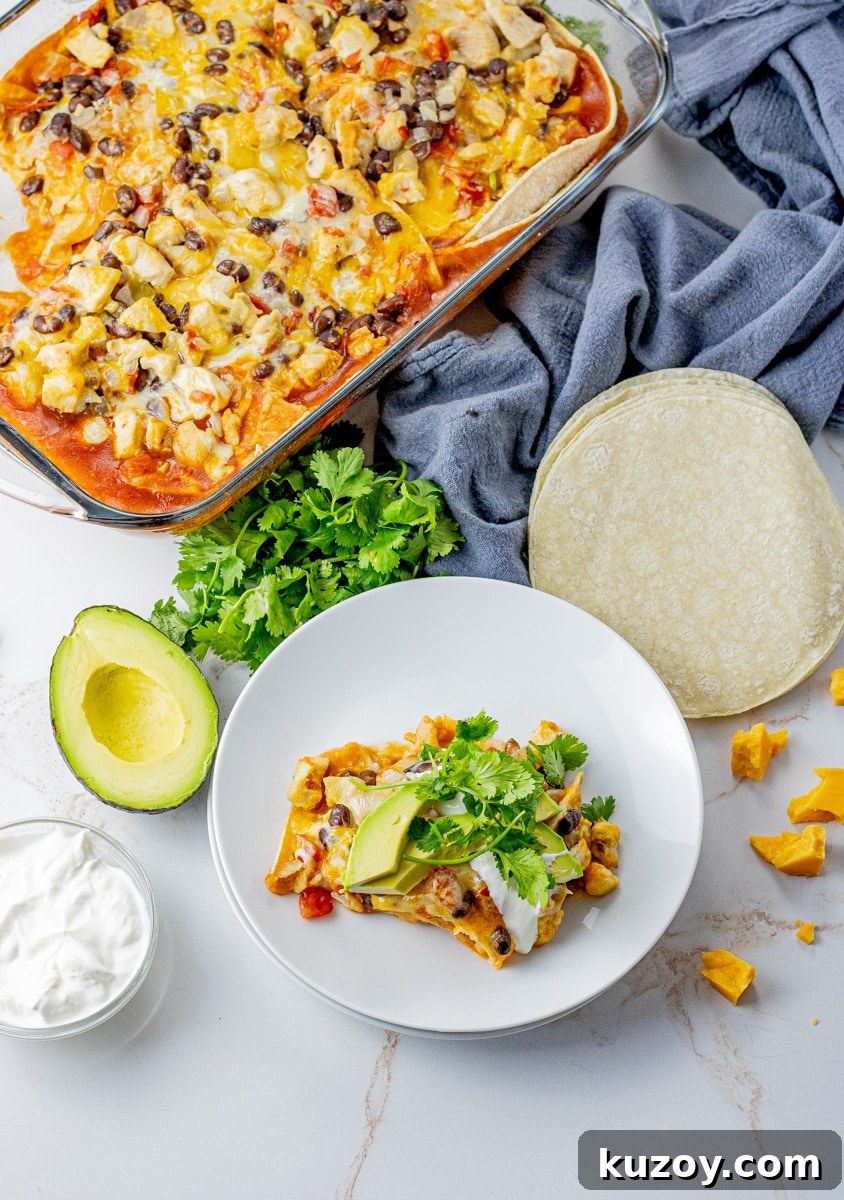 a pan filled with a layered tortilla casserole alongside a white plate with a slice of the casserole on it