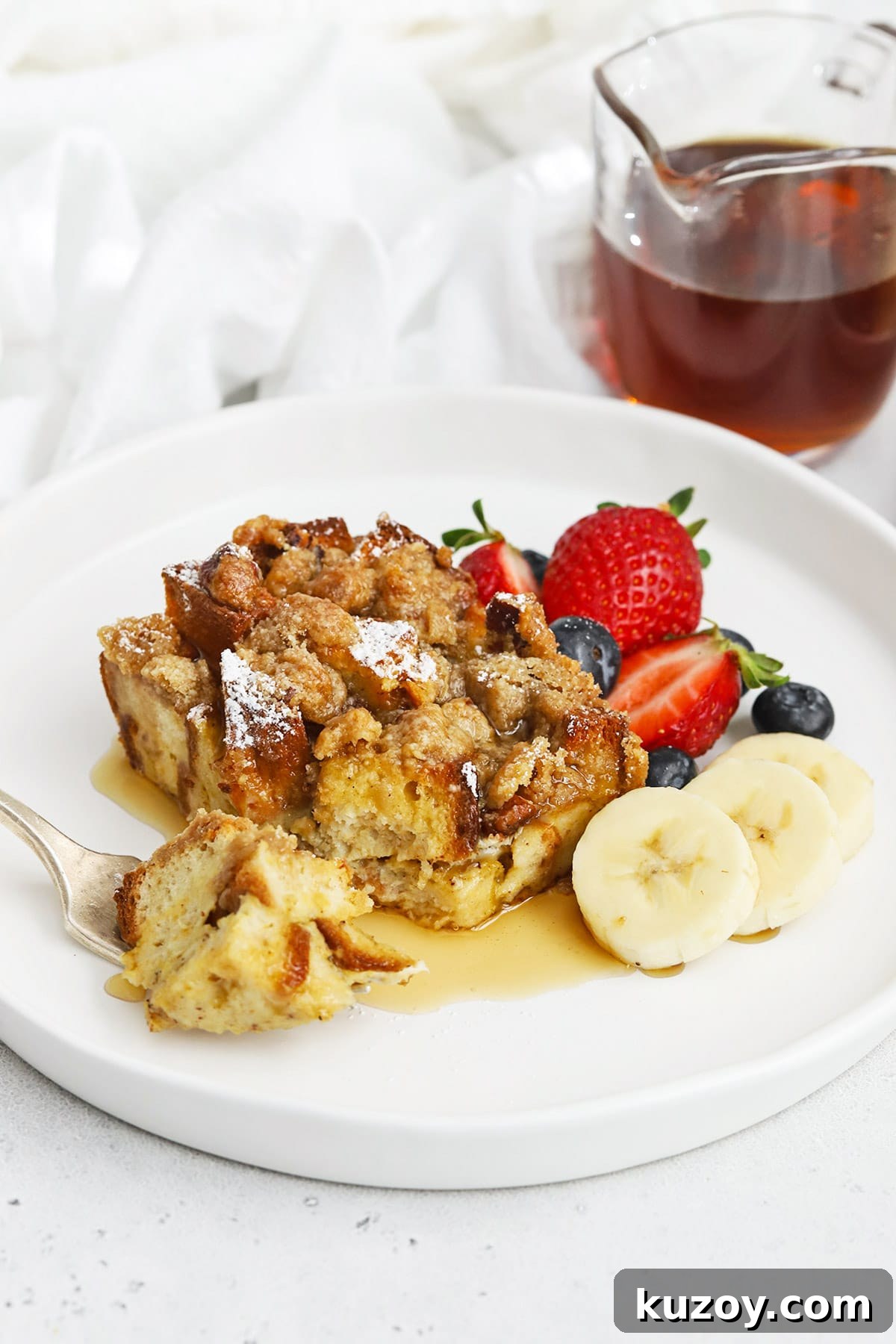 Gluten-Free Eggnog French Toast Casserole Recipe for Holidays 15 Front view of gluten-free eggnog french toast casserole topped with powdered sugar and maple syrup