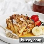 Front view of gluten-free eggnog french toast casserole topped with powdered sugar and maple syrup
