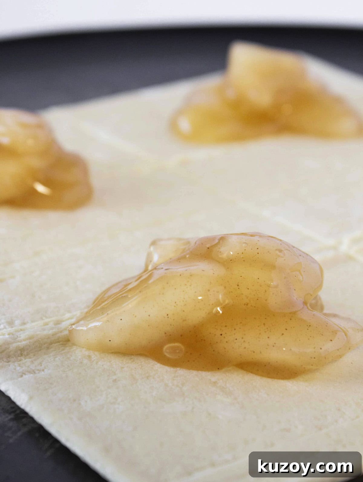 Caramel Apple Turnovers Recipe: Flaky Pastry with Gooey Filling 4 Adding apple pie filling to the top of the puff pastry.