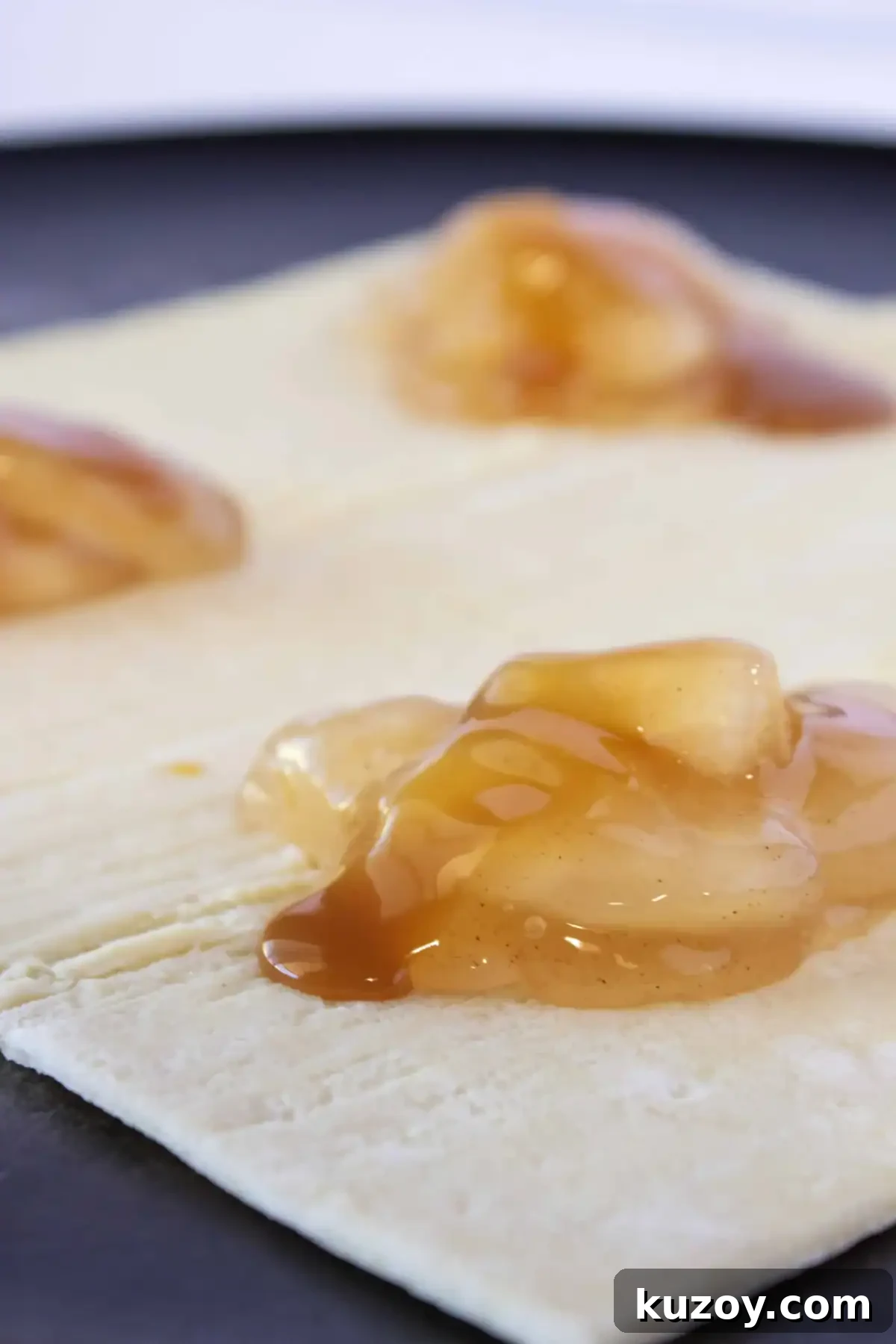 Caramel Apple Turnovers Recipe: Flaky Pastry with Gooey Filling 5 Adding caramel sauce to the top of the apples.