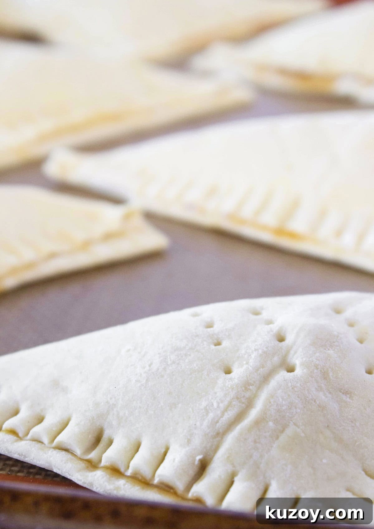 Caramel Apple Turnovers Recipe: Flaky Pastry with Gooey Filling 6 Folding the puff pastry over the apples and crimping with a fork.