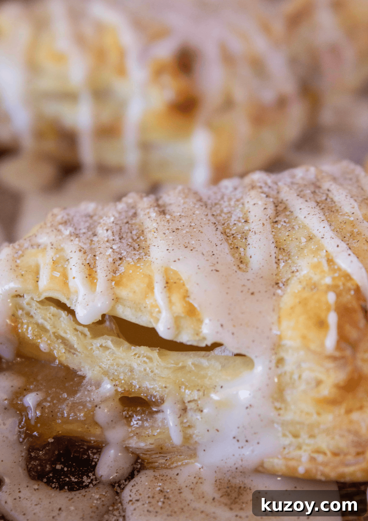 Caramel Apple Turnovers Recipe: Flaky Pastry with Gooey Filling 9 Adding the glaze to the top of the baked apple turnovers.