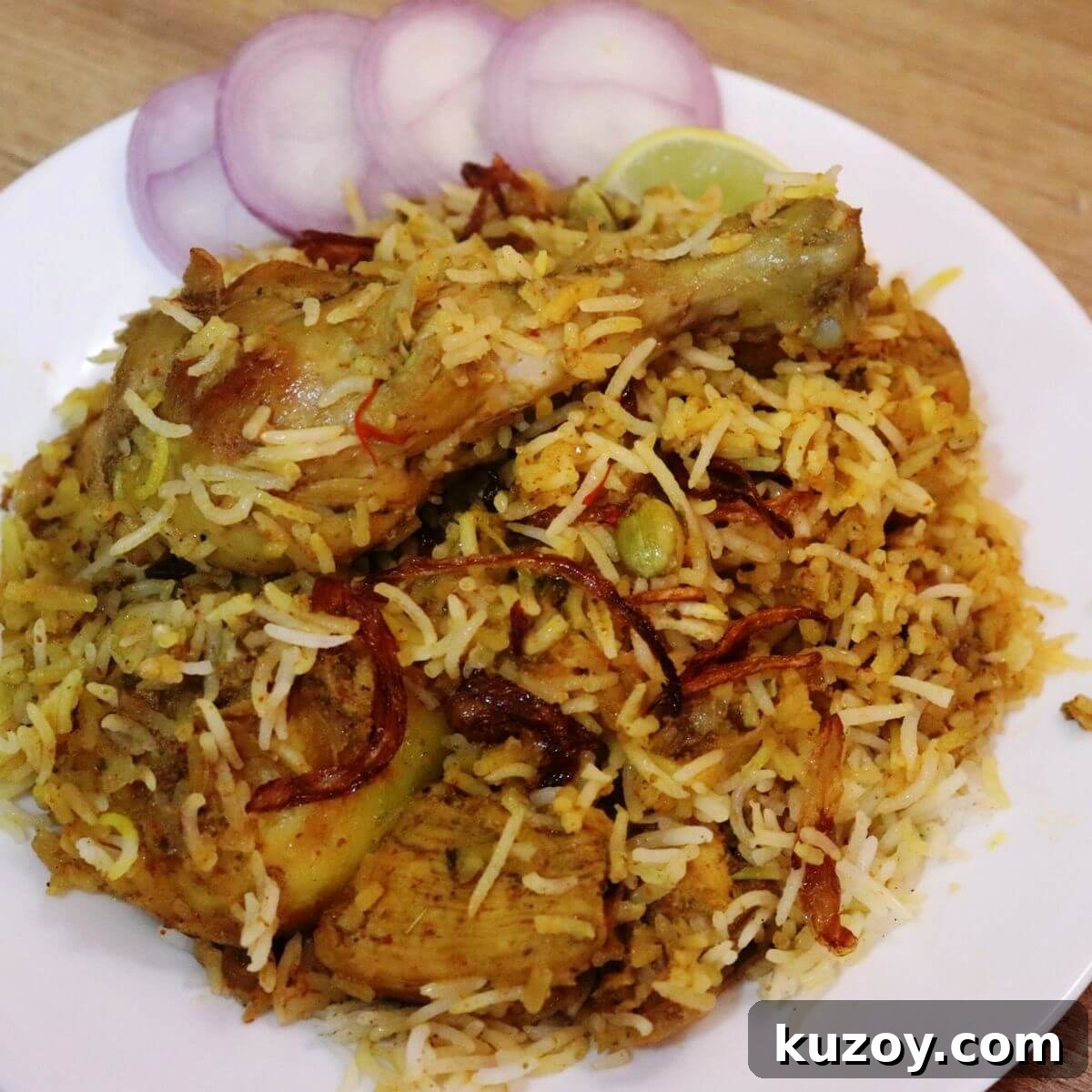 kolkata chicken biryani served on a white plate.