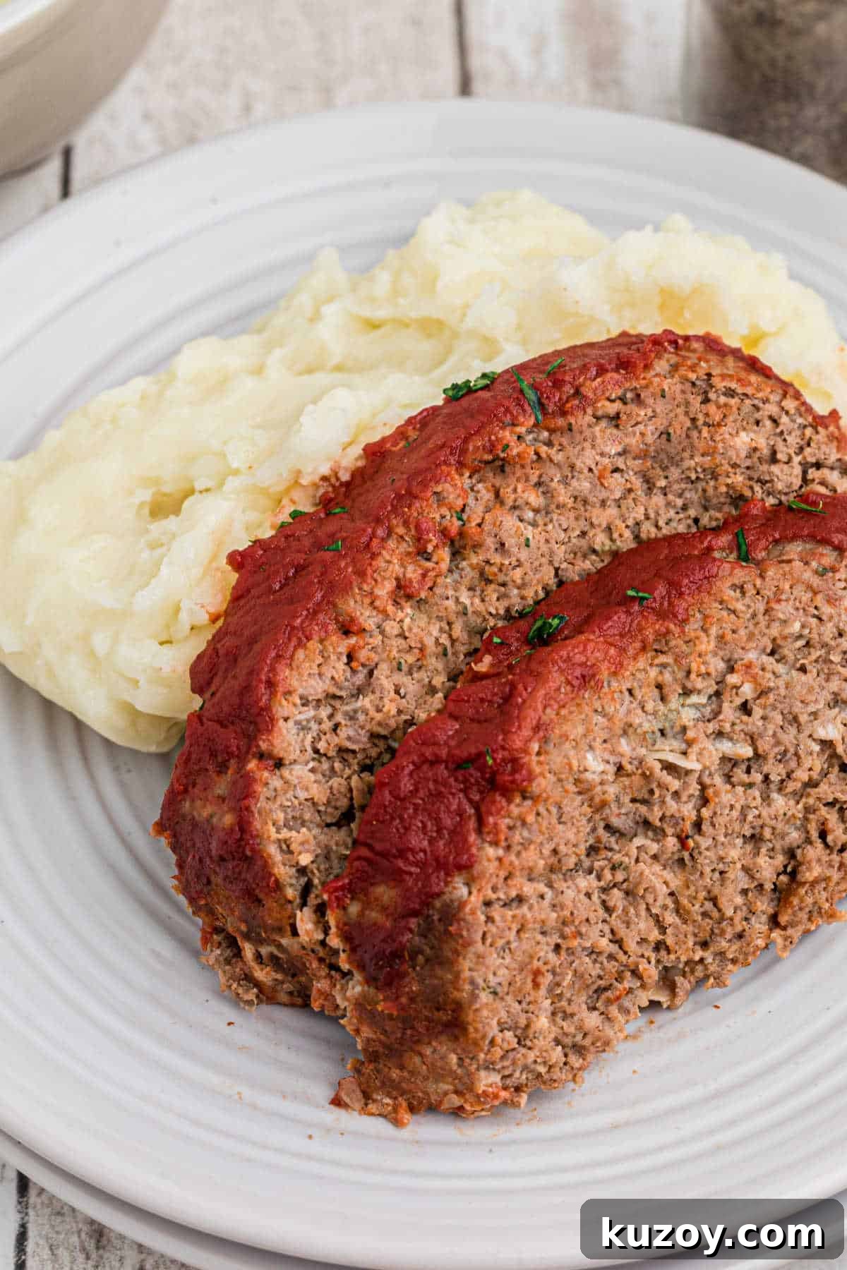 Spooky Monster Meatloaf Recipe for Halloween Dinner 6 Two slices of meatloaf against some mashed potatoes.