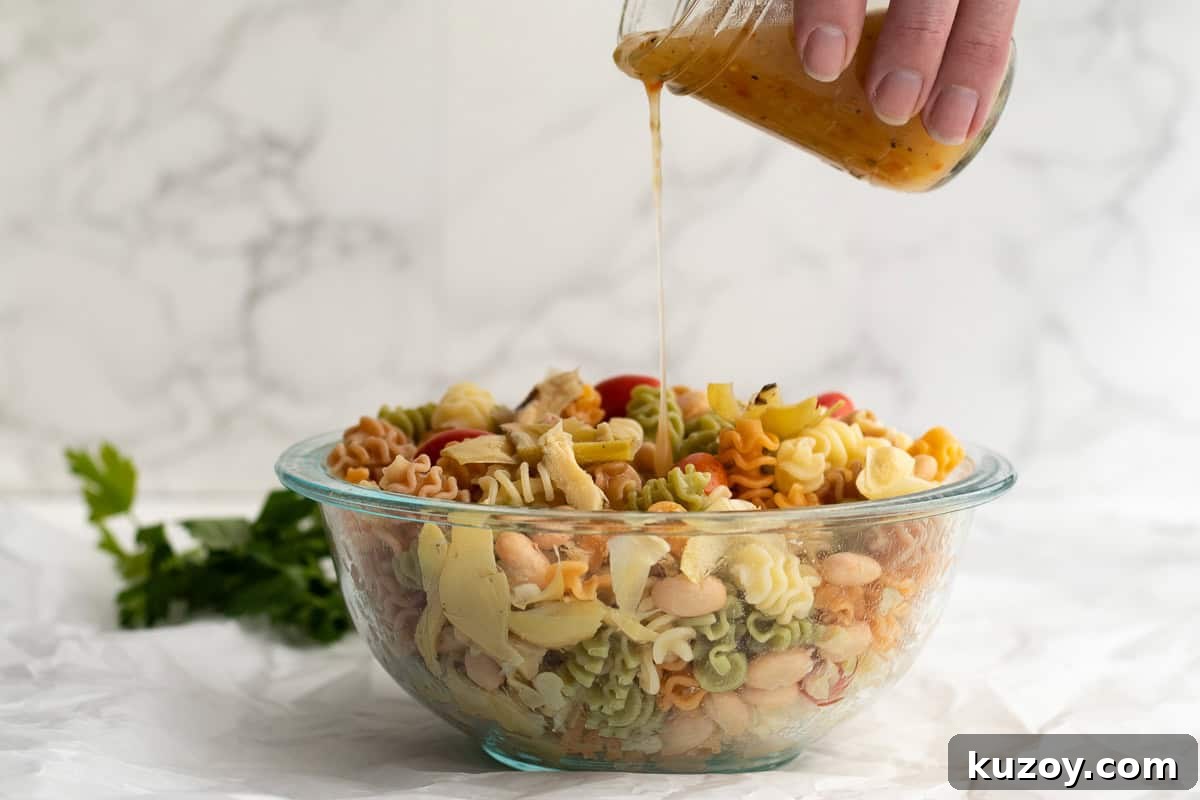 Zesty Italian Pasta Salad with 6 Simple Ingredients 6 dressing being poured over pasta salad