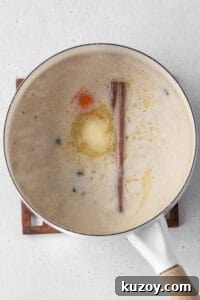 Creamy Dairy-Free Vegan Rice Pudding Recipe 6 Milk, butter, cinnamon, and an orange peel added to the pot of cooked rice.