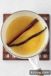 Creamy Dairy-Free Vegan Rice Pudding Recipe 9 Syrup heated in a pot with a vanilla bean and cinnamon stick.