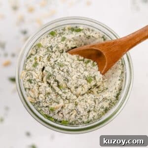 Homemade Ranch Seasoning Mix Recipe for Dips & Dressings 11 An overhead view of a jar of homemade ranch seasoning, with a small wooden spoon scooping some out.