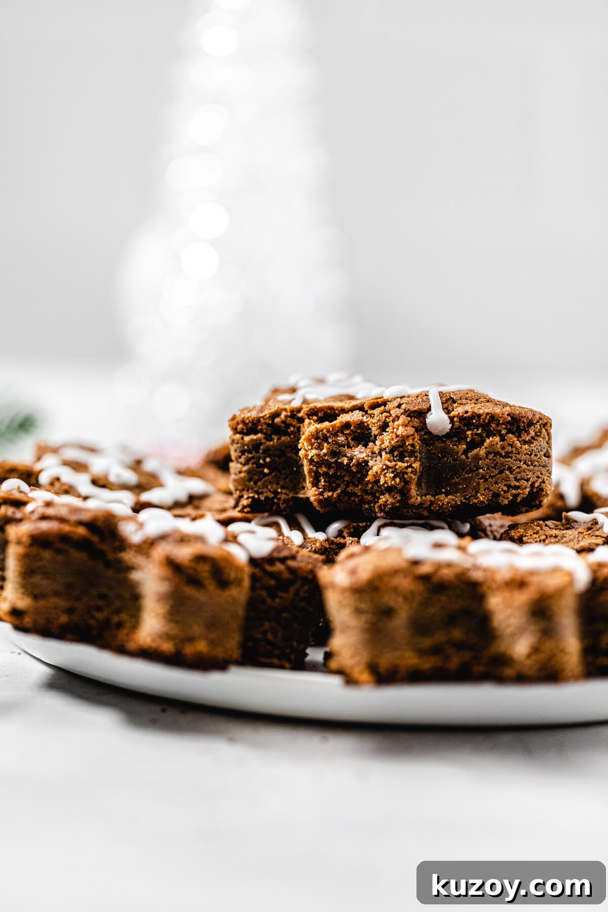 blondies on a white platter with a half eaten blondie stacked on top