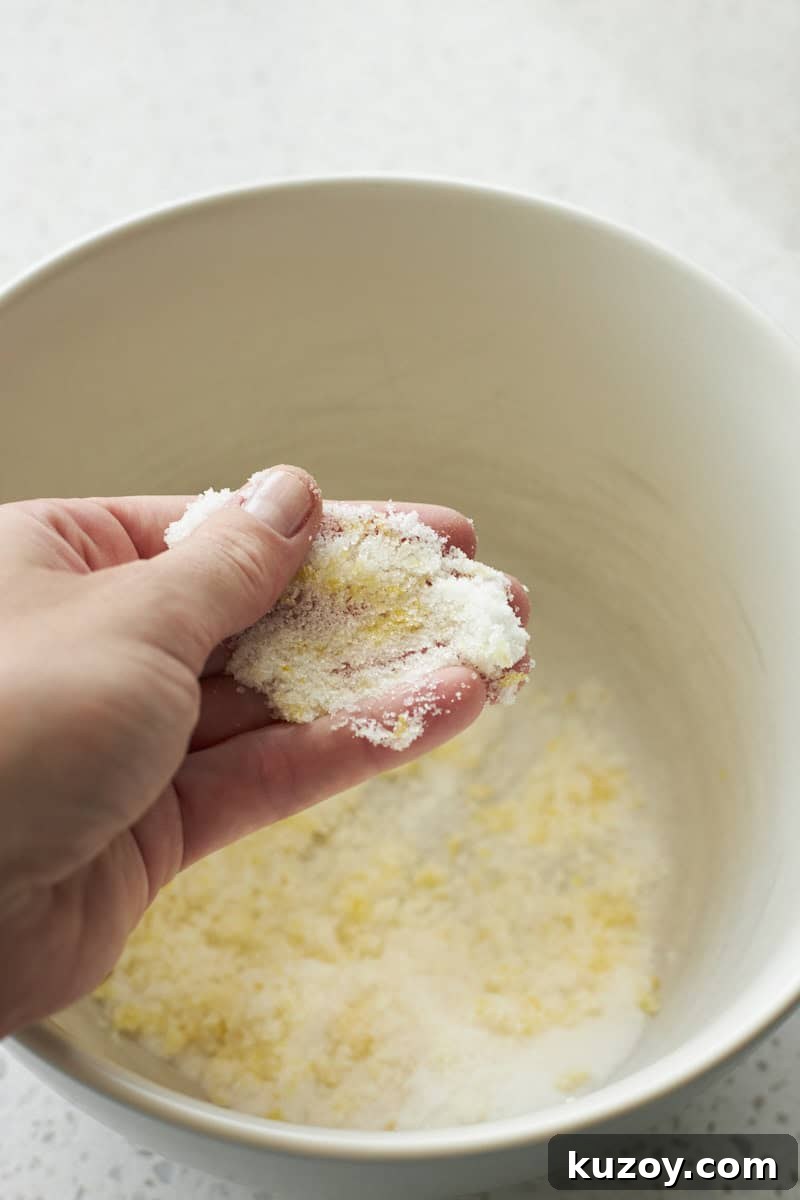 Sugar and lemon zest being pressed together.