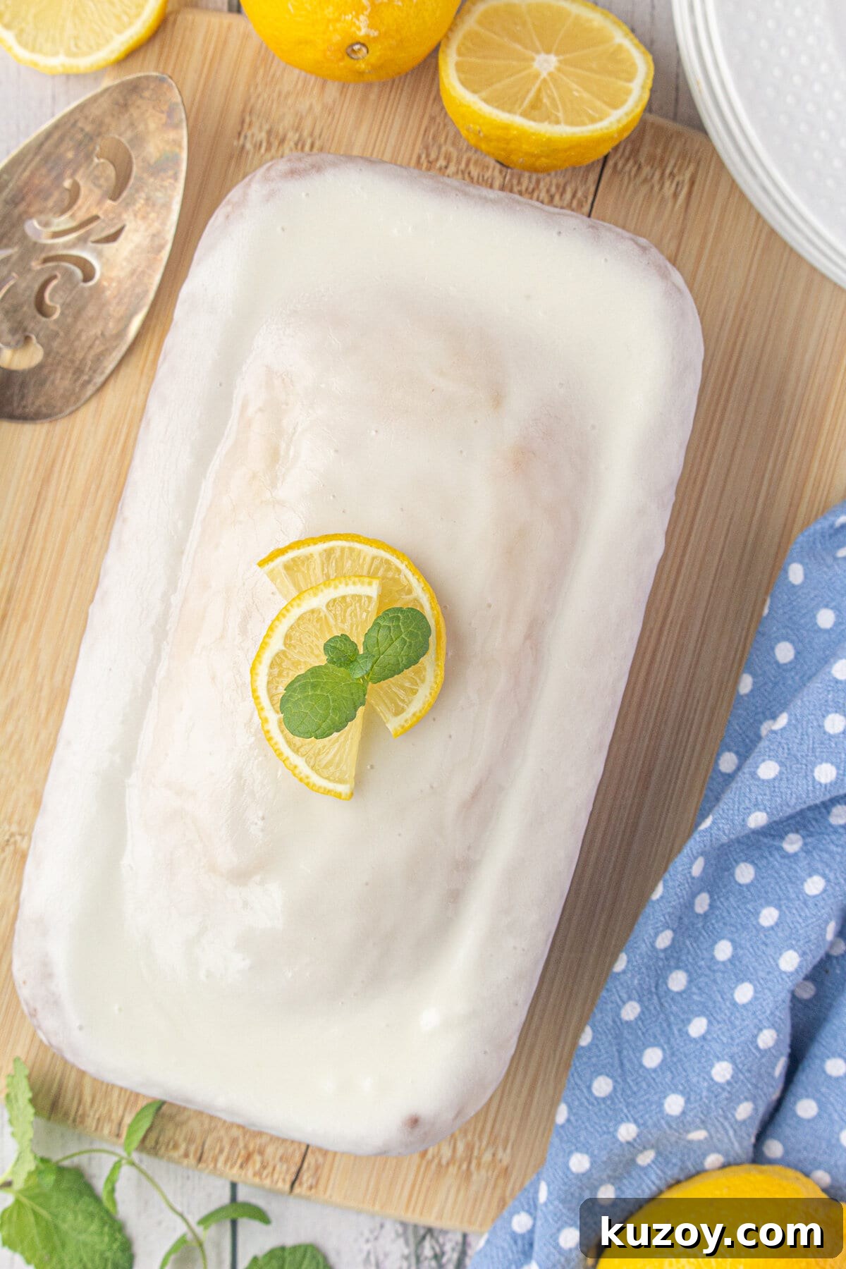 Starbucks-Style Lemon Loaf Recipe: Moist Citrus Quick Bread 9 An overhead view an iced lemon loaf, topped with a lemon slice garnish.