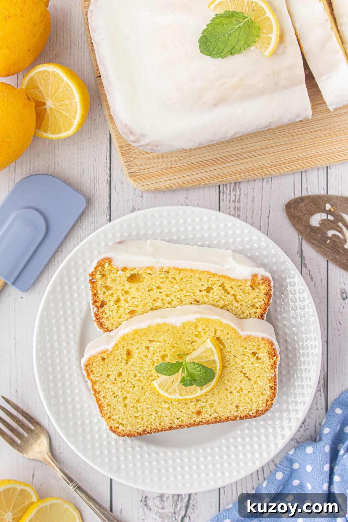 Starbucks-Style Lemon Loaf Recipe: Moist Citrus Quick Bread 10 Two slices of iced lemon loaf on a white plate.
