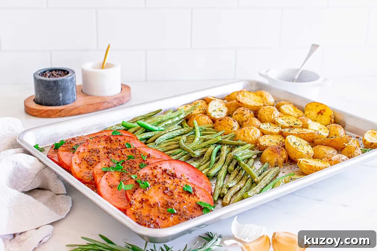 One-Pan Baked Ham Dinner with Roasted Vegetables 2 A sheet pan with ham, green beans and potatoes.