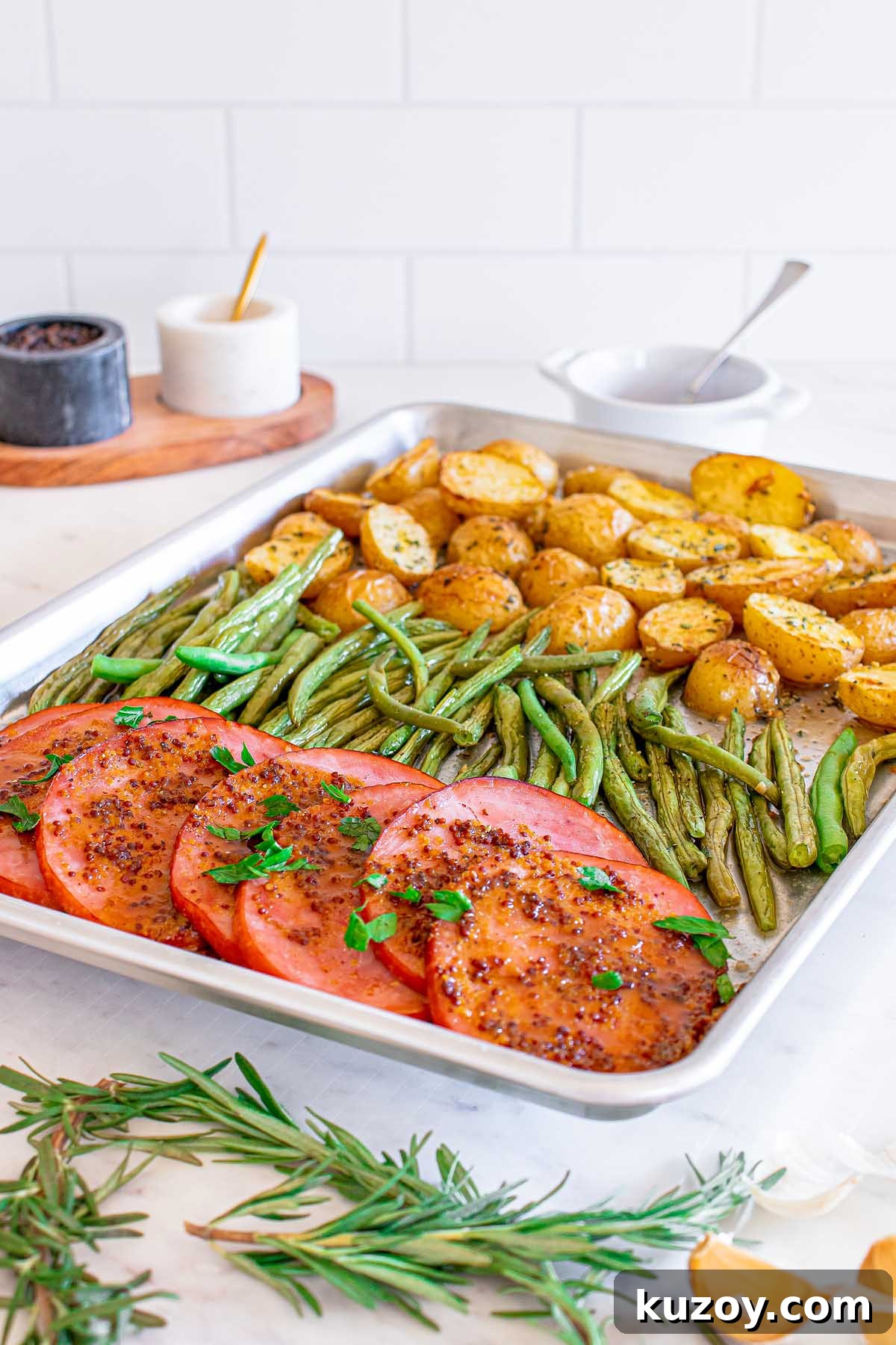 One-Pan Baked Ham Dinner with Roasted Vegetables 4 Ham, roasted potatoes and green beans garnished with fresh herbs.