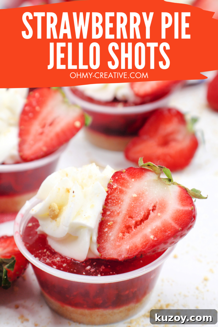 A tasty strawberry jello shot topped with whipped cream and a slice of strawberry.