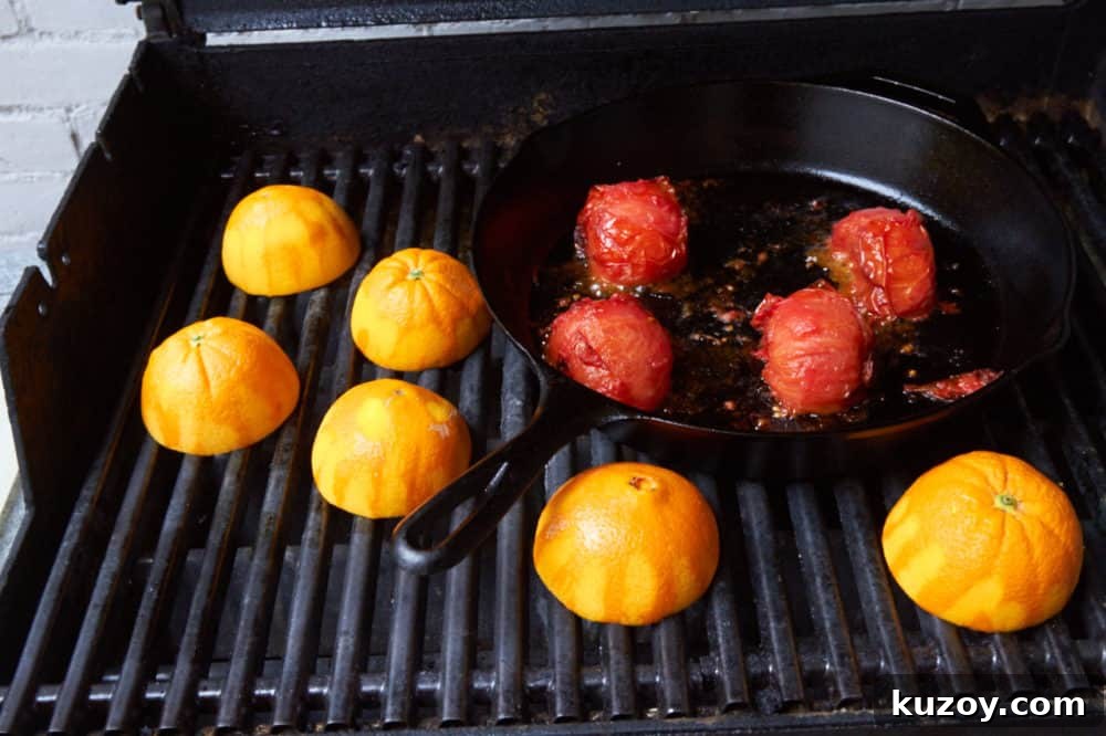 Orange-Almond Mole Sauce: Quick Recipe for Rich, Zesty Flavor 4 Tomatoes in a cast iron skillet and orange halves all roasting on a grill.