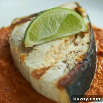 Grilled halibut topped with lime on a bed of mole sauce.