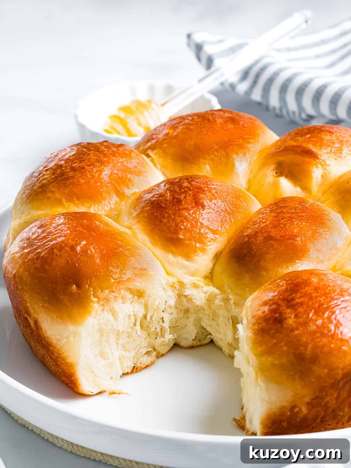 Homemade Brioche Rolls Recipe for Soft, Buttery Loaves 3 Soft and sweet brioche rolls with fluffy interior on a white plate.