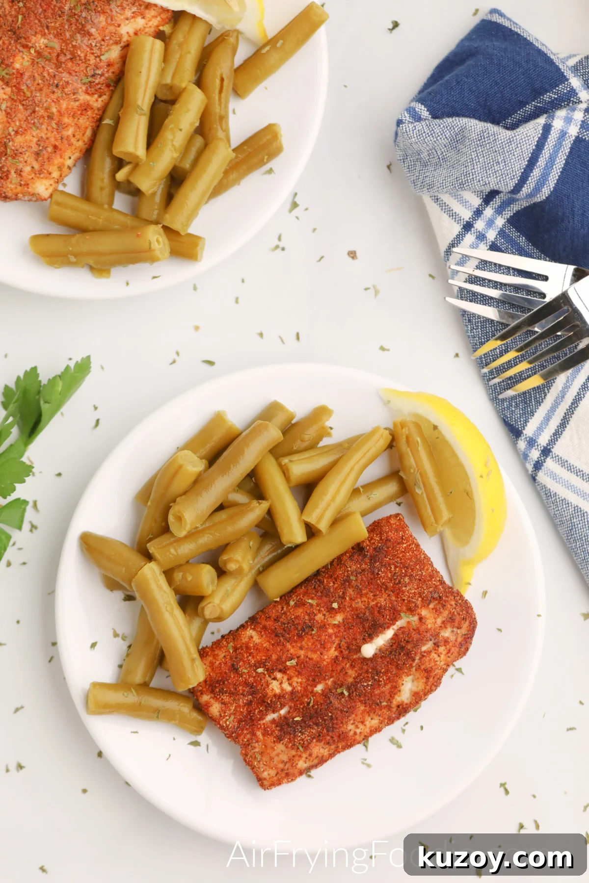 Overhead shot of Air Fryer Mahi Mahi on a plate with green beans and a lemon slice. 