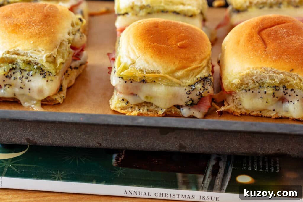 Baked ham and poppy seed biscuits on a parchment-lined tray.