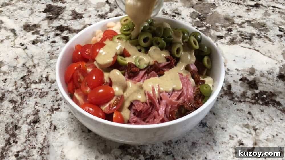 Pouring Italian Dressing over Pasta Salad