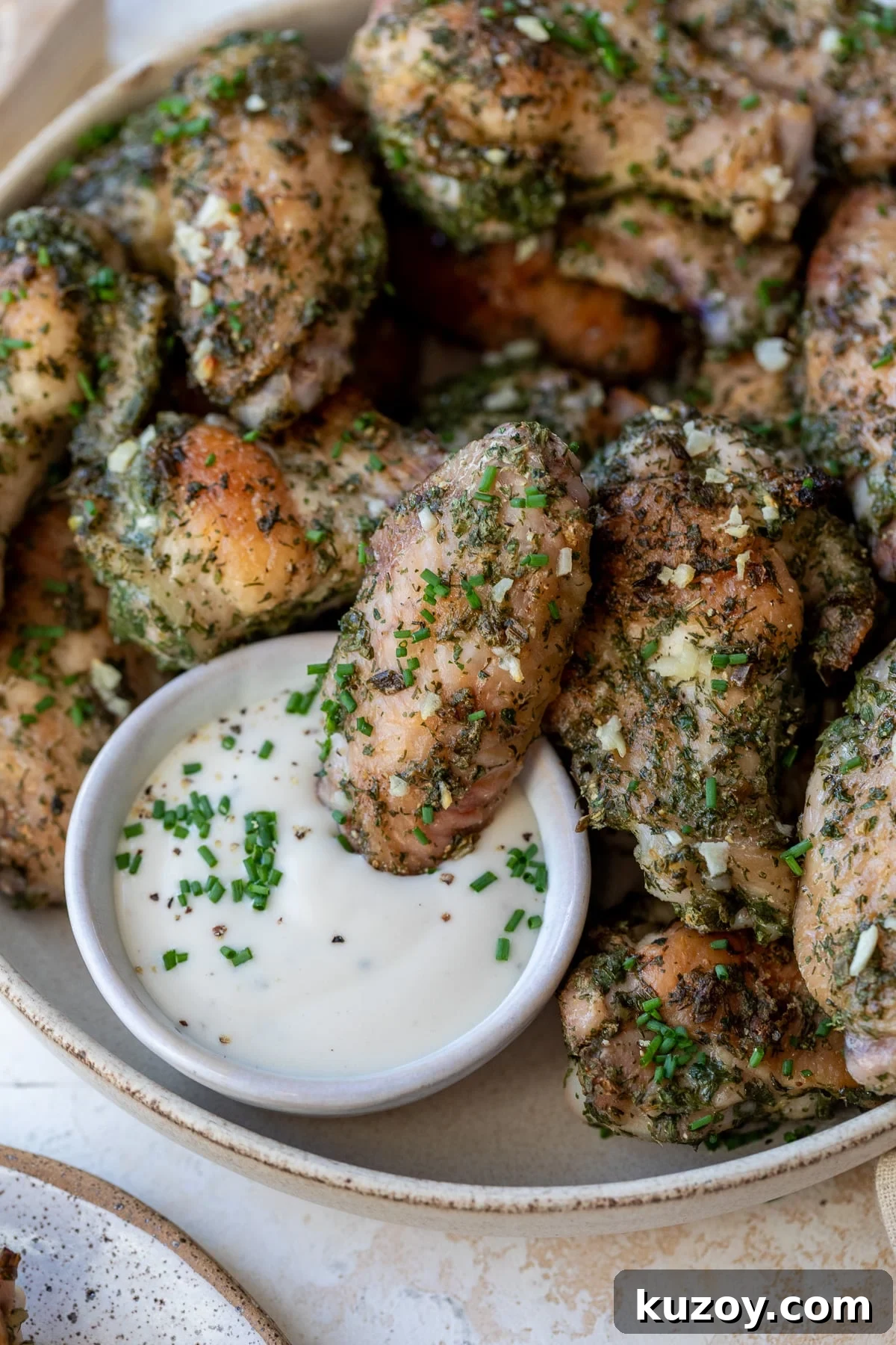close-up of ranch chicken wings on a plate with ranch dressing on the side
