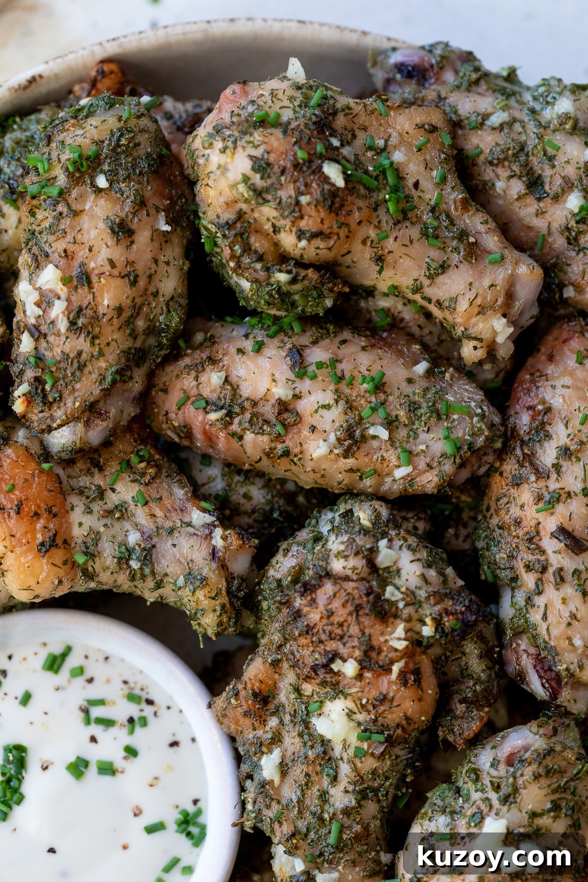 close-up of ranch chicken wings on a plate with ranch dressing on the side