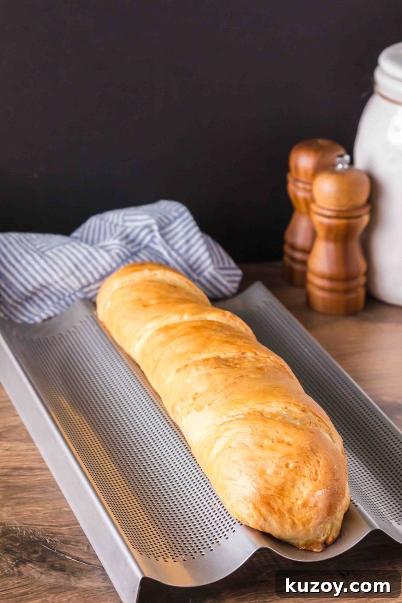 A baked golden-brown French baguette fresh from the oven on a a French Baking Pan – Hostess At Heart