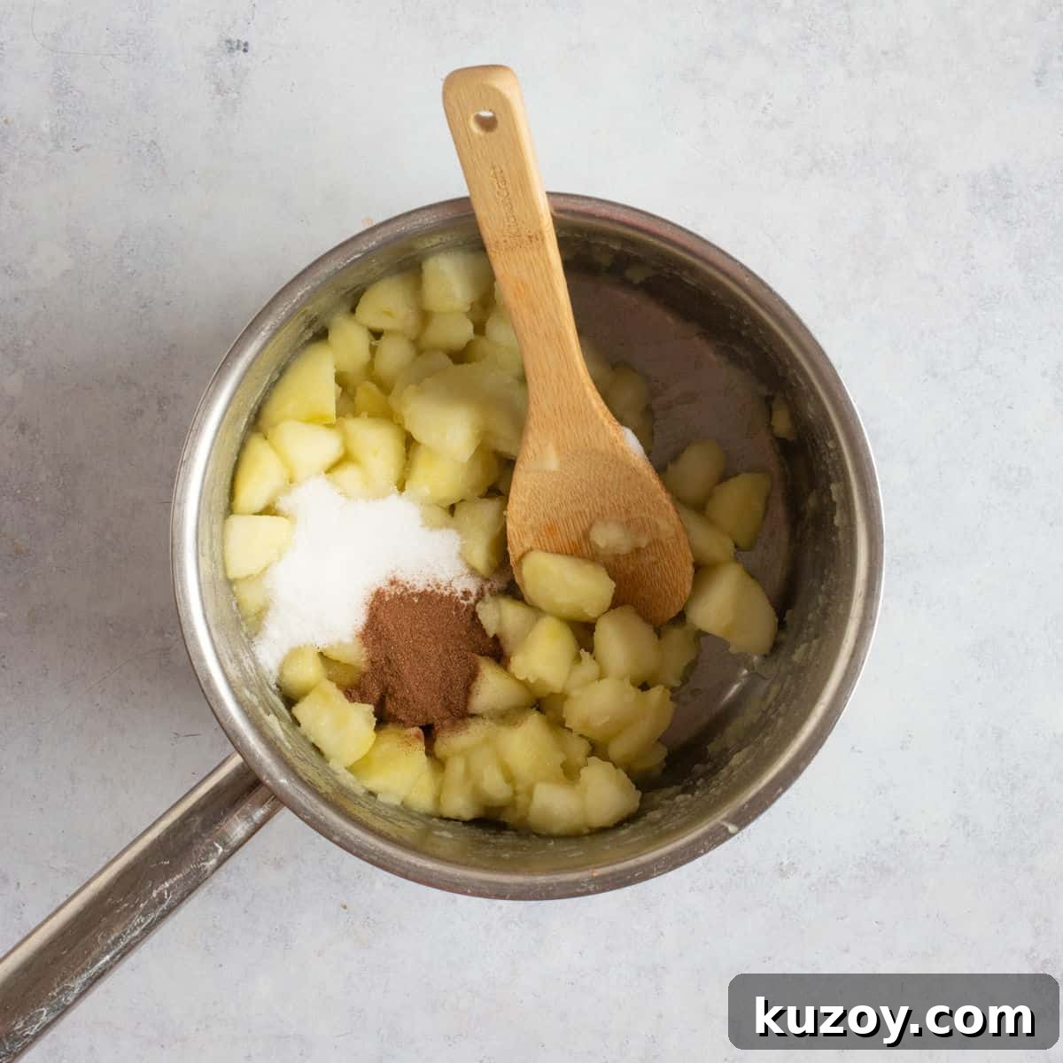 Stewed apples with cinnamon and sugar added to the pan.