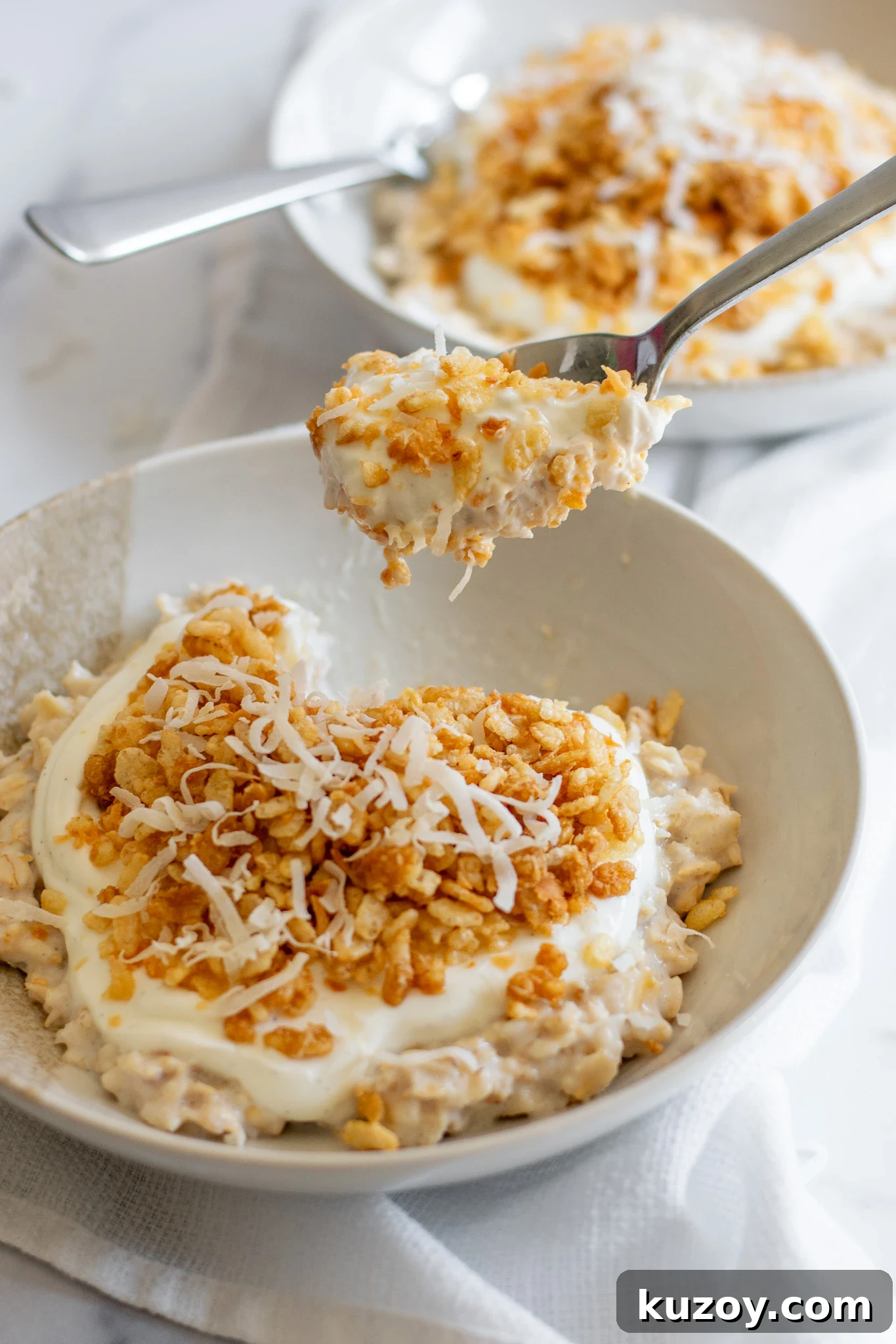 A spoonful of porridge with coconut puffed rice and vanilla yoghurt.