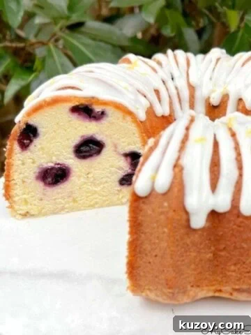Lemon Blueberry Pound Cake, sliced, on a cake pedestal.