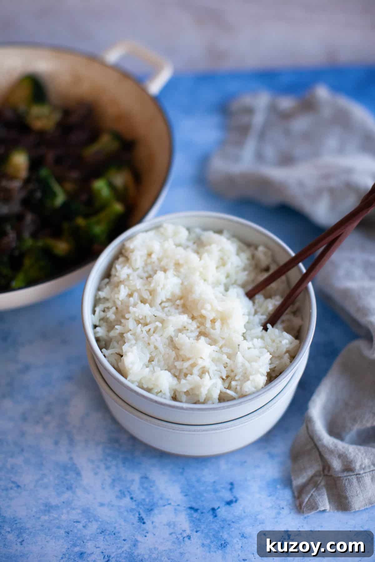 Instant Pot jasmine rice in a small white bowl with chopsticks.