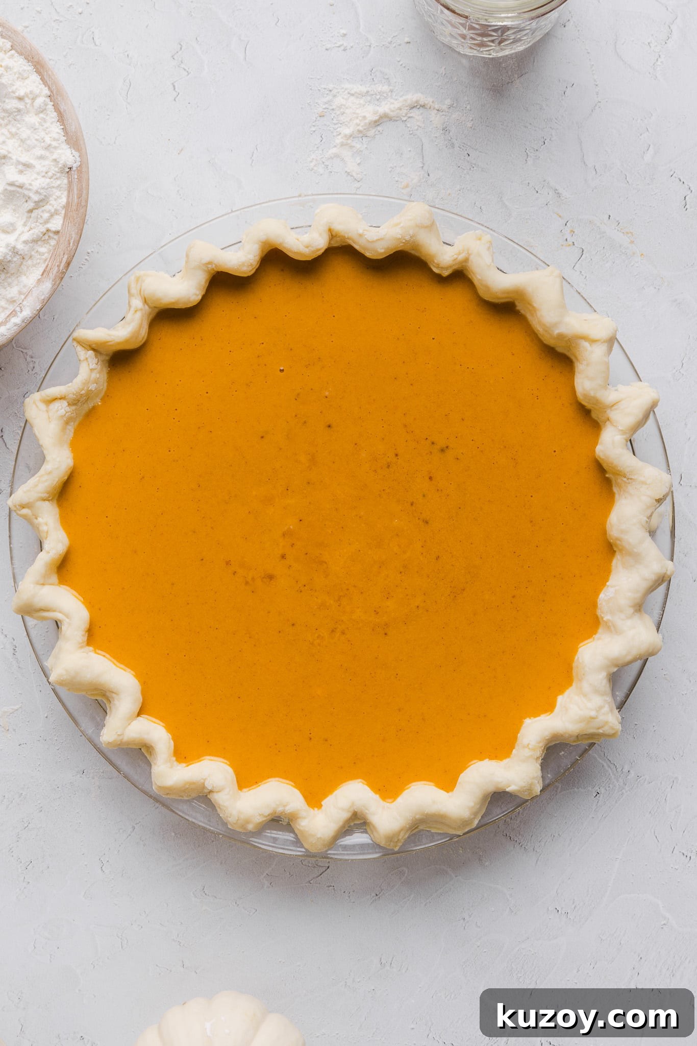 Healthy pumpkin pie filling poured into a crust in a pie pan.