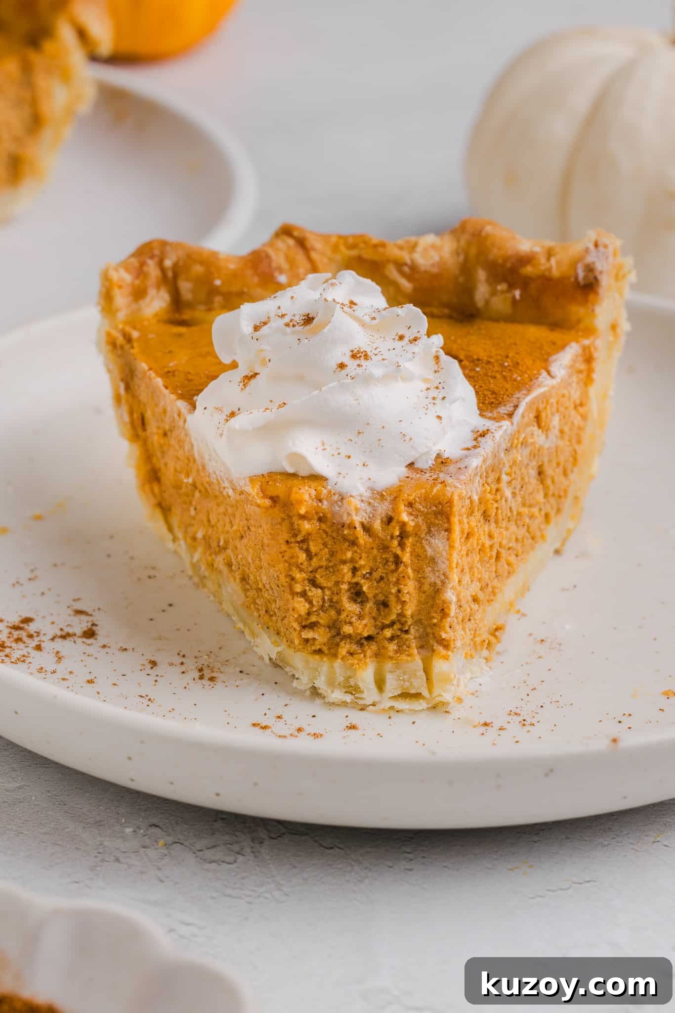 A slice of healthy pumpkin pie with whipped cream.