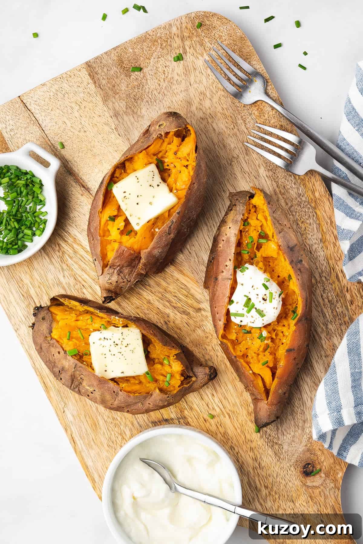 A cutting board with three slow cooker sweet potatoes with toppings.