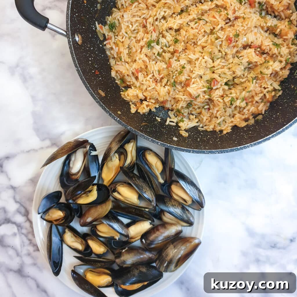 A pan of tomato rice next to a plate of cooked mussels.
