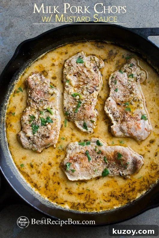 Juicy Pork Chops Braised in Milk with Mustard Sauce in a cast iron skillet 