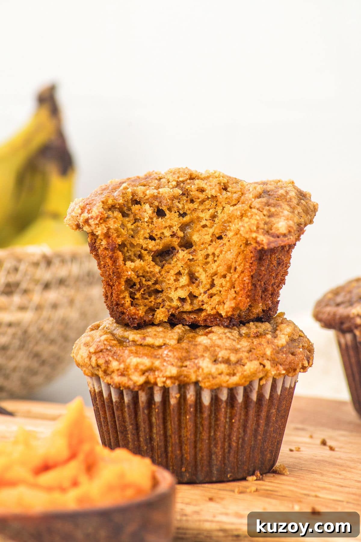 Half-eaten pumpkin banana muffins stacked on each other