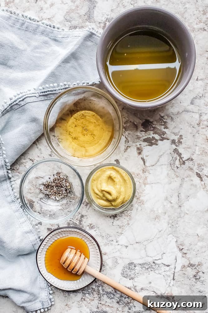 Overhead shot of vinaigrette ingredients in several bowls on a white counter.