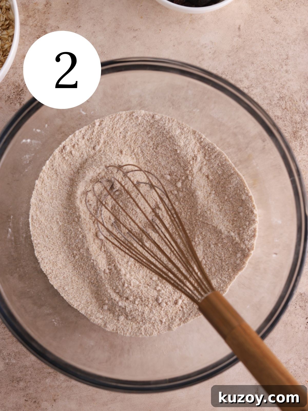 Flour, sugars, and spices mixed together with a whisk in a bowl.