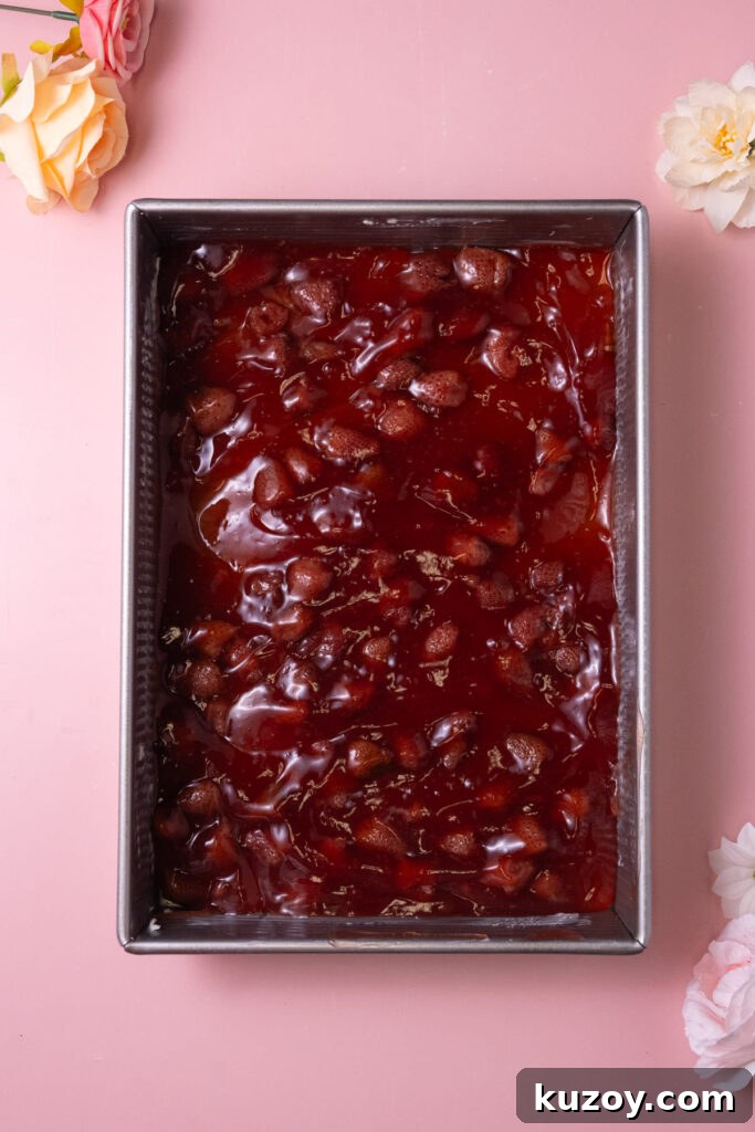 Canned strawberry pie filling in a greased casserole dish.