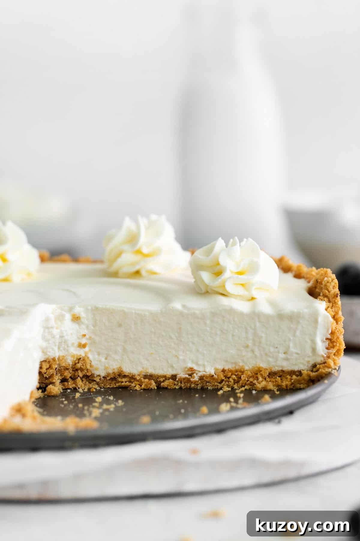 A whole gluten-free no-bake cheesecake in a dish, with a slice taken out